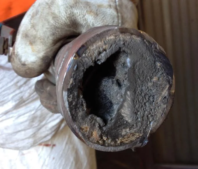 Cross-section of an SNCR urea pipe with deposits narrowing the passage