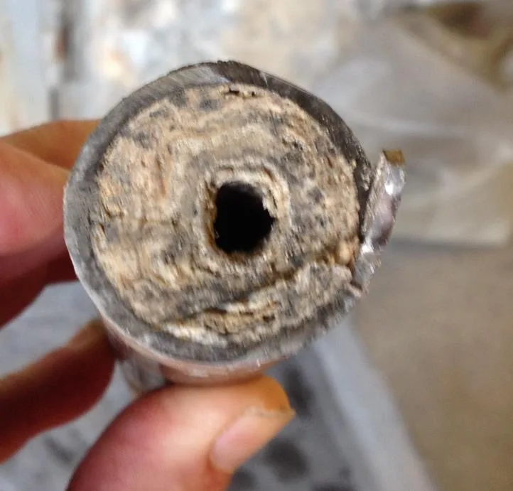 Cross-section of an SNCR urea pipe almost closed by urea deposits