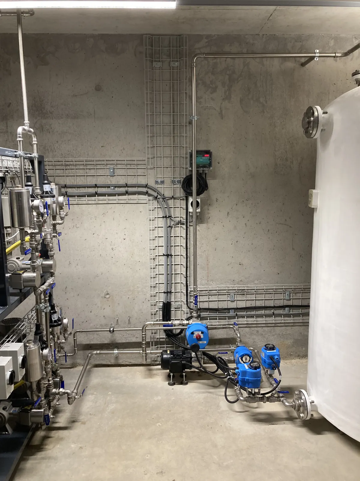 Locale tecnico dell’impianto SNCR con linee di dosaggio, pompe e serbatoio di miscelazione urea – centrale a biomassa, Svizzera