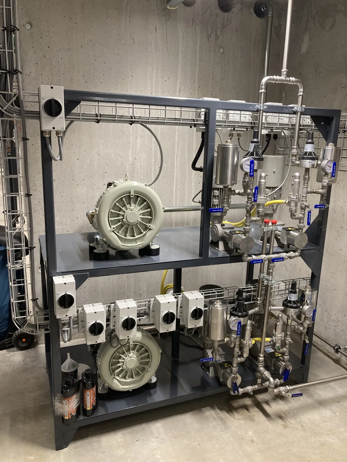 Skid di dosaggio SNCR installato nel locale tecnico della centrale a biomassa, con pompe dosatrici e soffianti di raffreddamento – Svizzera